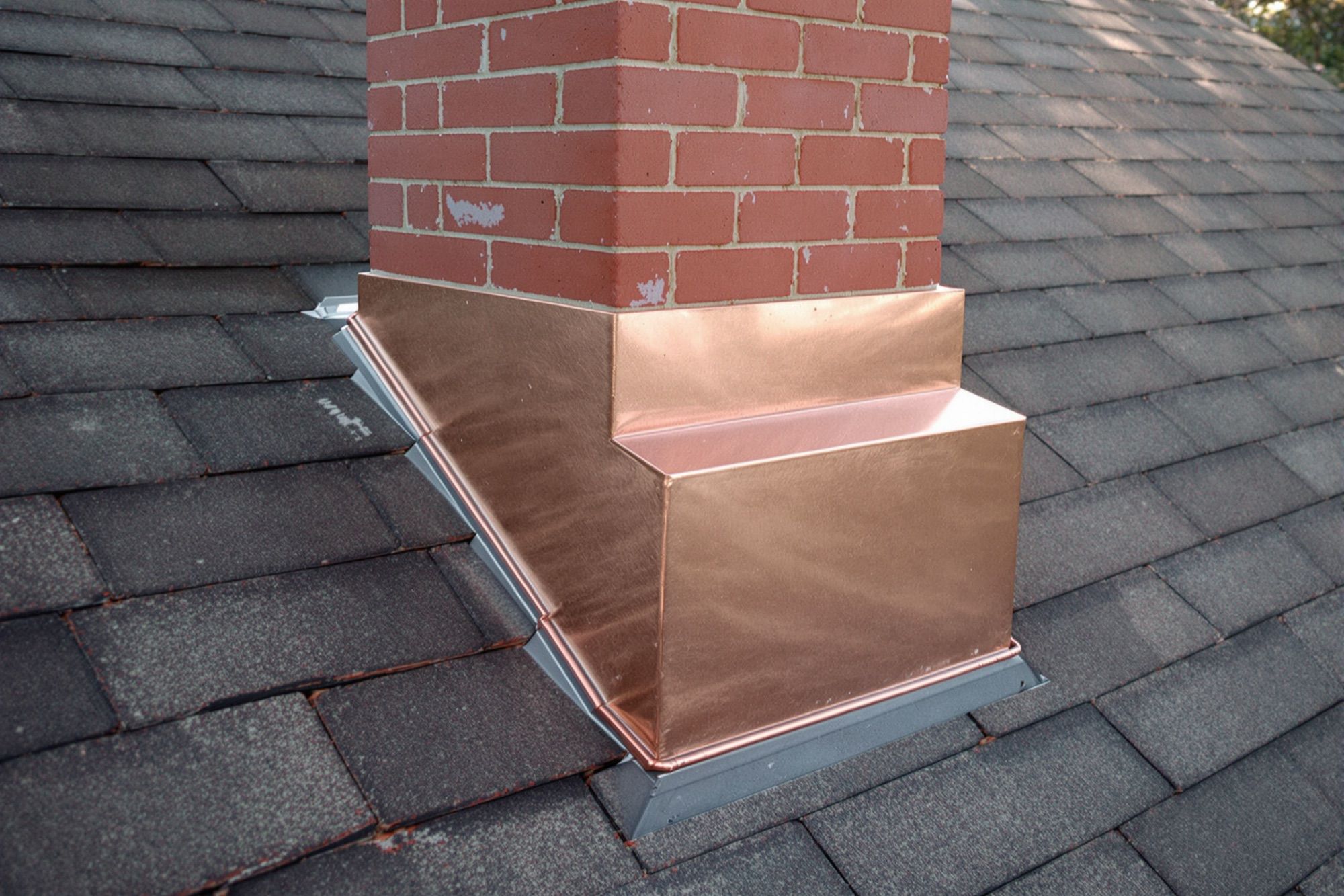 Copper step and counter flashing around a brick chimney