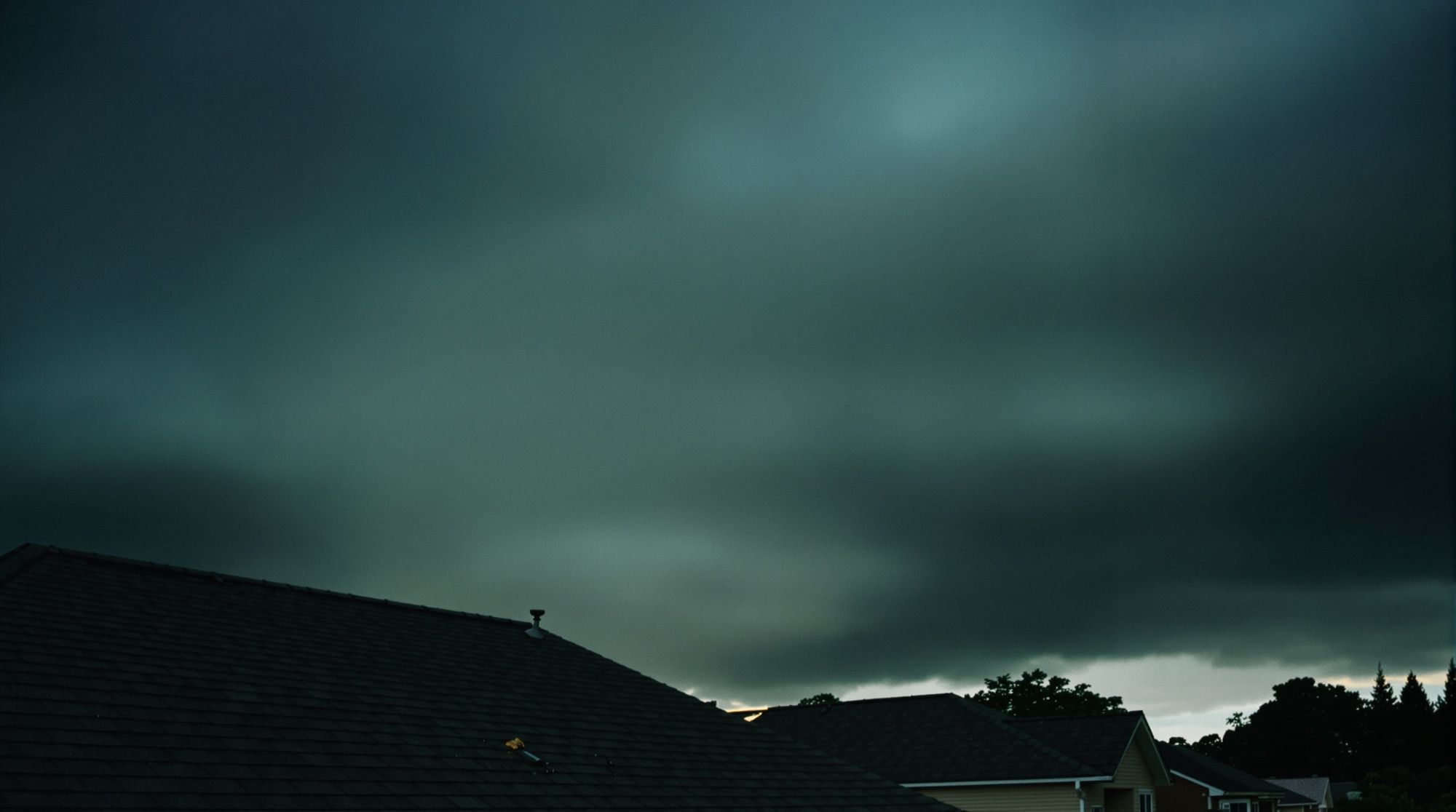 Storm clouds building over a row of rooftops
